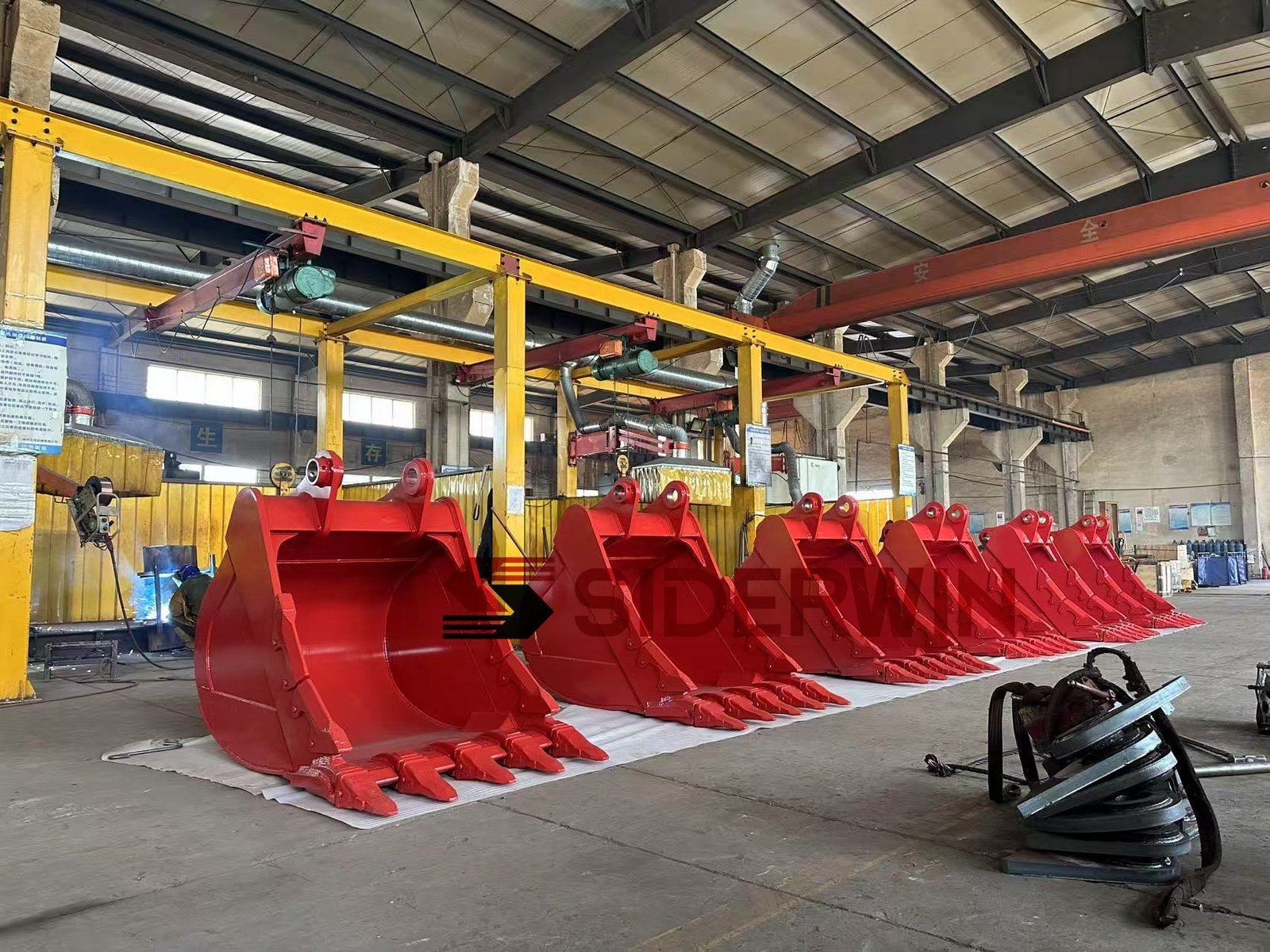 Row of red excavator buckets showing different assembly sizes