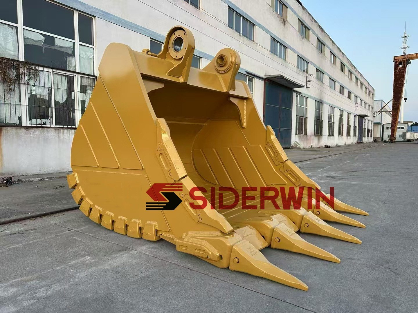Yellow excavator bucket showing mounting ears and teeth