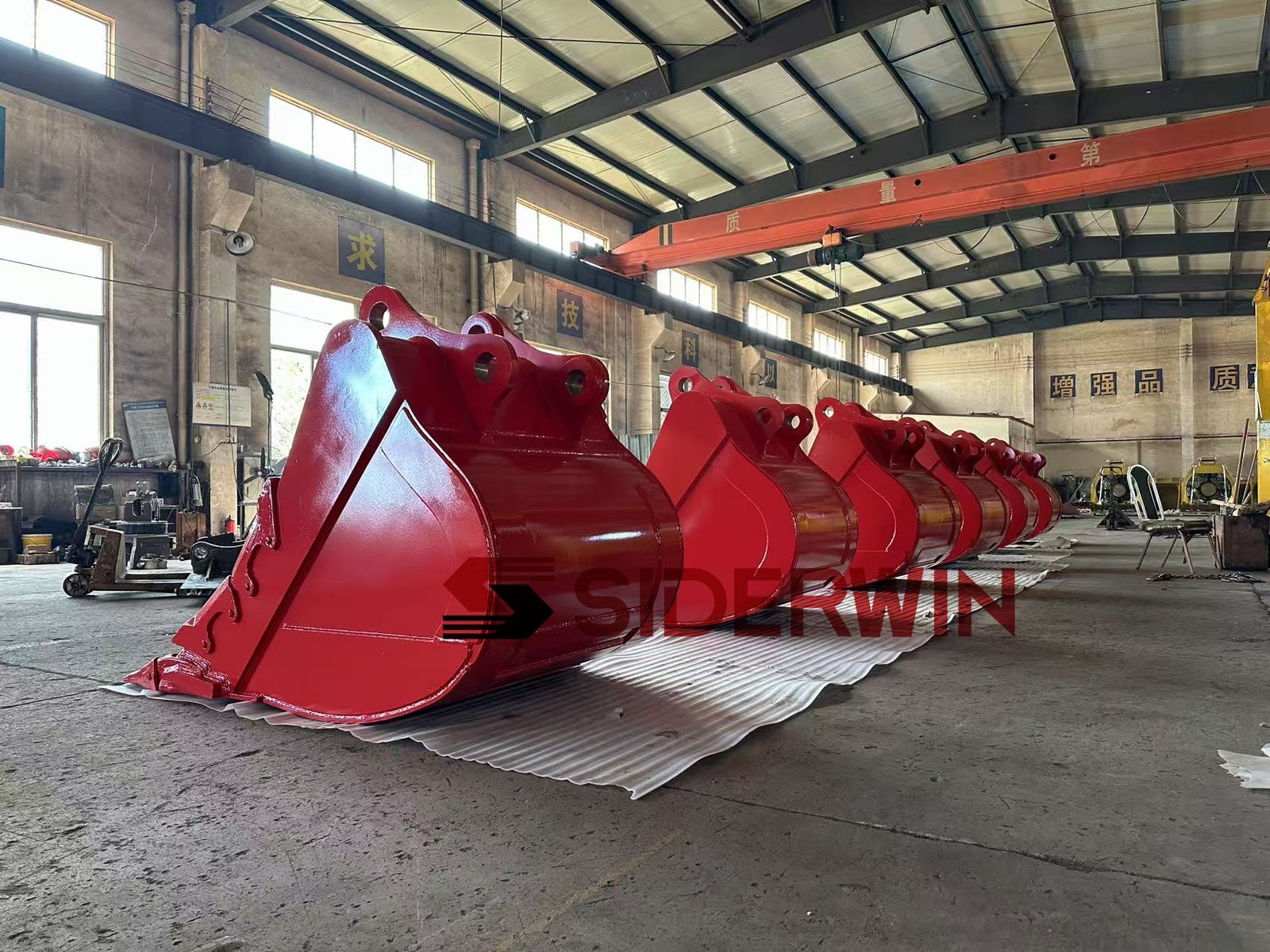 Side profiles of red excavator bucket shells and mounting ears