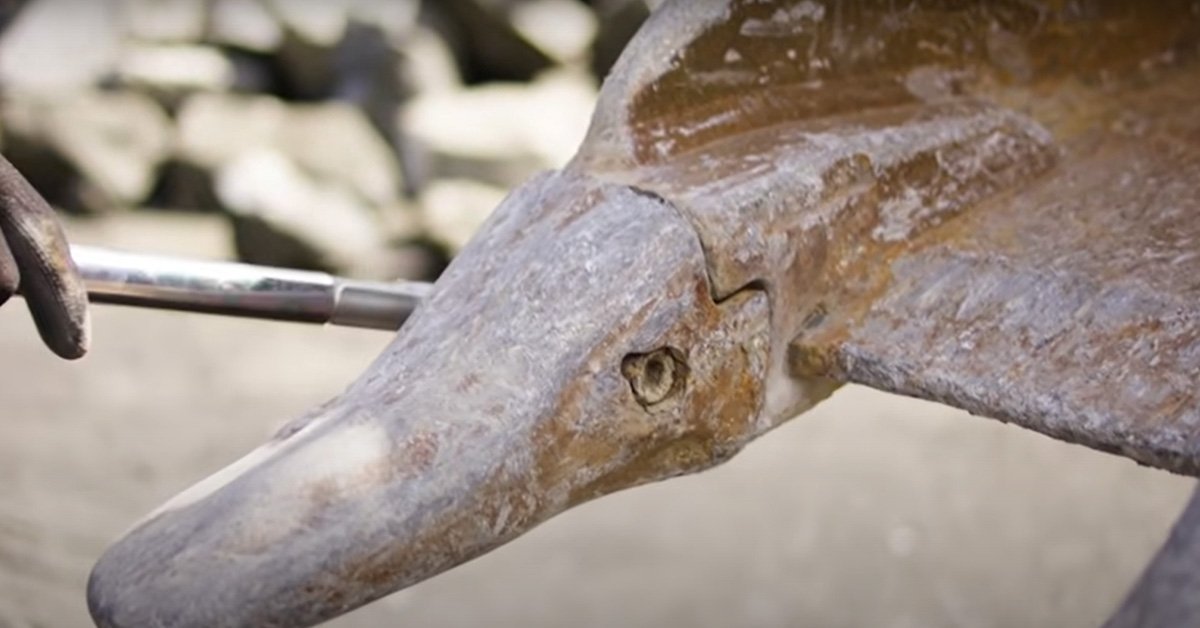Close view of a used bucket tooth and its retaining pin