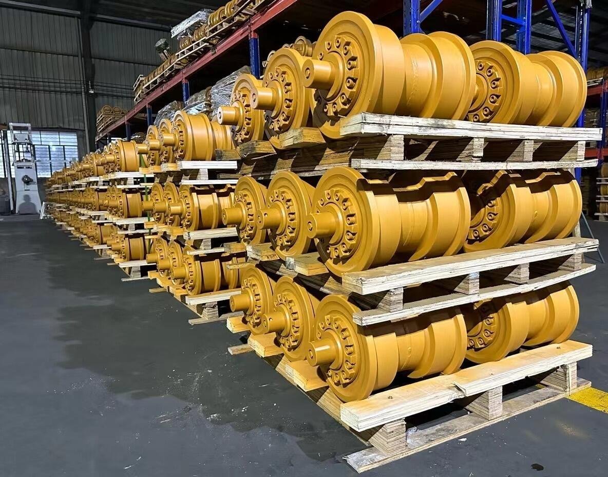 Yellow undercarriage roller assemblies stacked on pallets
