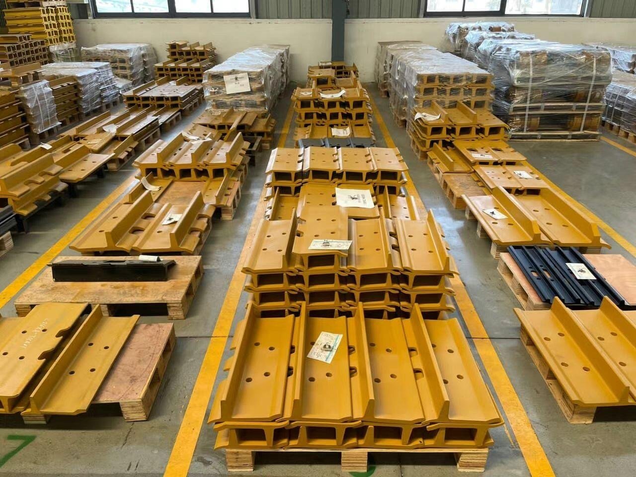 Different steel track shoes stacked on pallets
